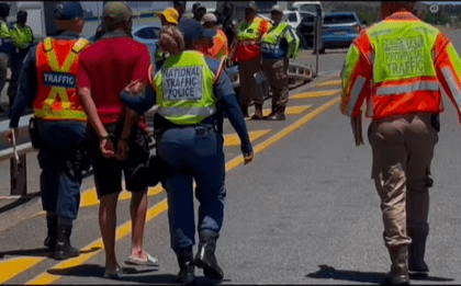 Eastern Cape Traffic Officials Escorting An Arrested Motorist During A Road Block Picture By ECDoT