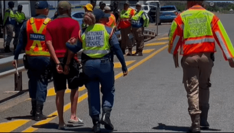 Eastern Cape Traffic Officials Escorting An Arrested Motorist During A Road Block Picture By ECDoT