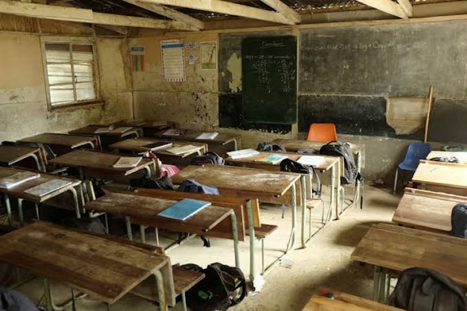 Abafundi behleli eklasini kwisikolo sikarhulumente eMpuma Koloni, befotwa ngasemva ukuze ubuso babo bungabonakali.