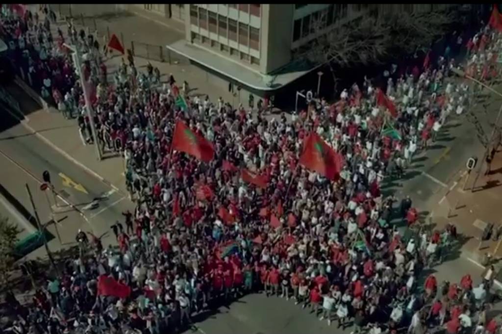 EFF supporters gather in large numbers while waving EFF flags during a political campaign event.