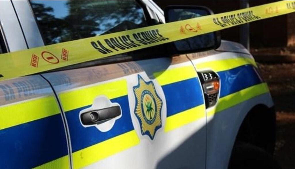 South African police vehicle behind crime-scene tape.